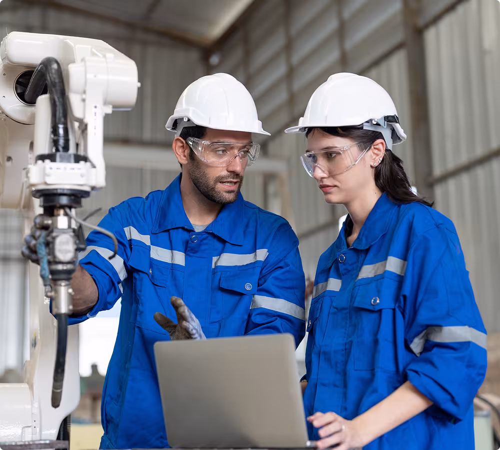 Industrial technicians analyzing machinery using a laptop